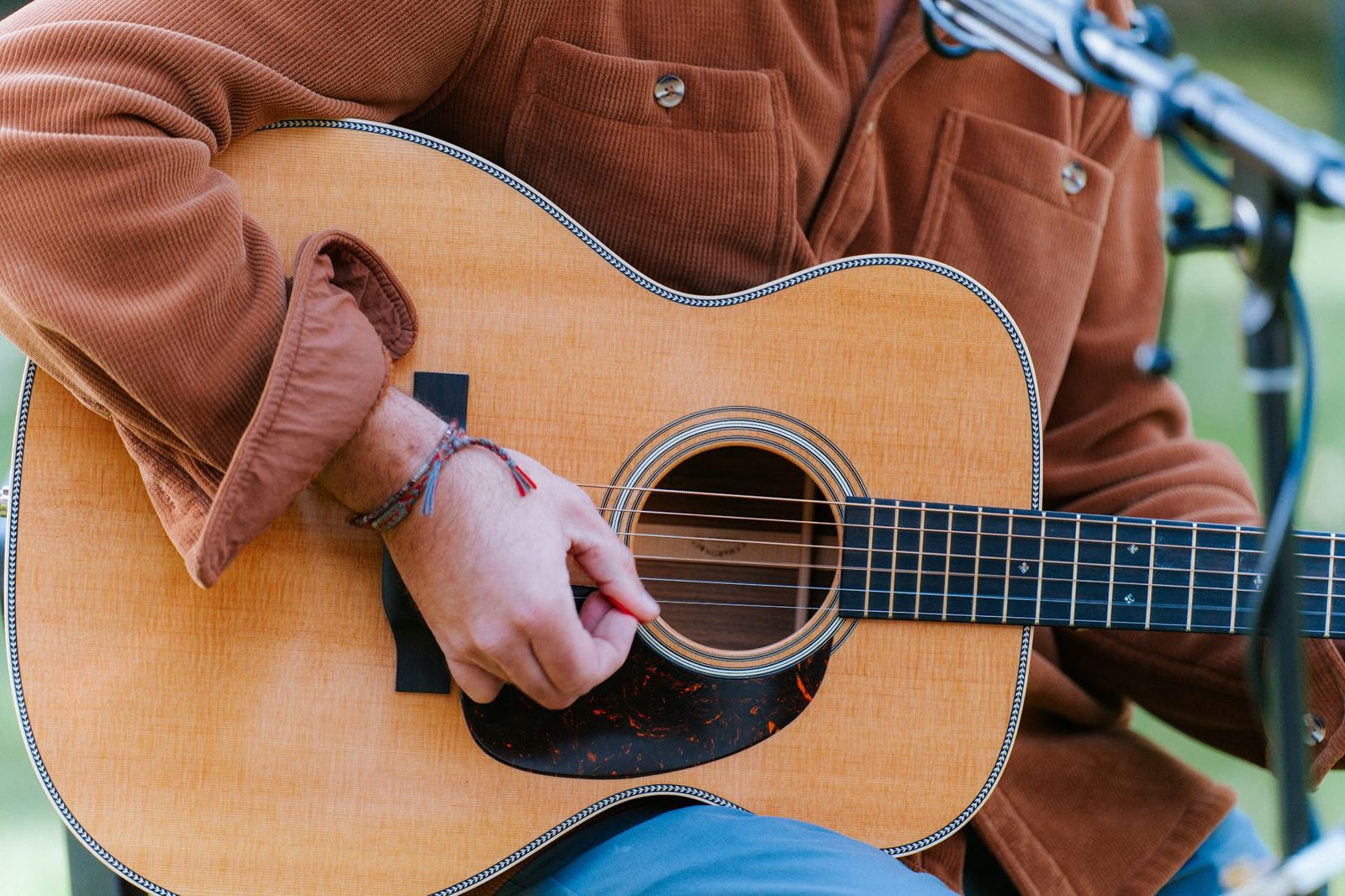 Close-up of John Crean strumming his acoustic guitar